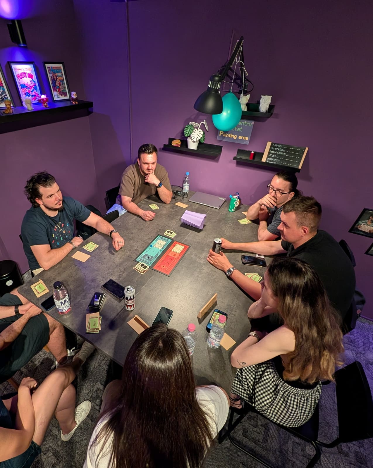 Grup de prieteni jucând un boardgame la masă