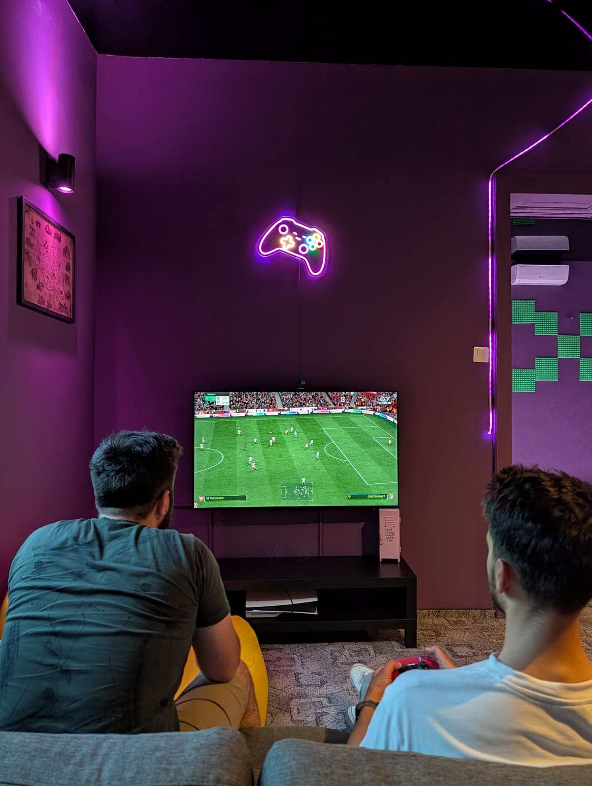 Doi jucători cu controllere PlayStation 5 (PS5) în gaming lounge-ul MOTRIX